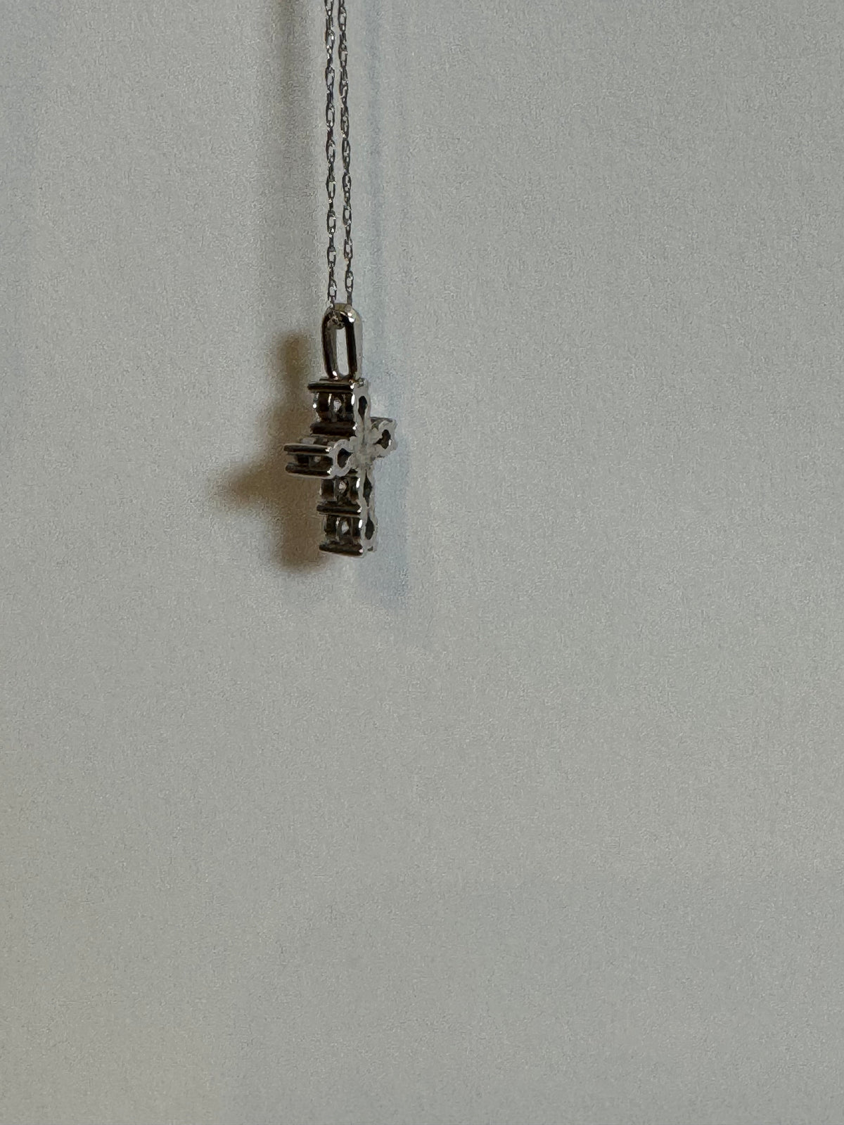 Detail of the gold chain and diamond cross pendant by Statement92